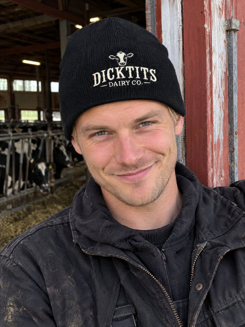 Dicktits Dairy Co. på svart Hatitude Beanie, buren av en yngre vuxen.