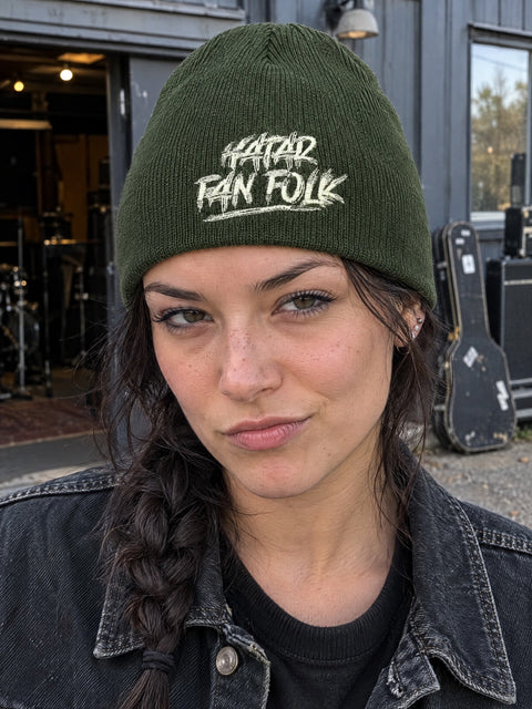 Hatar fan folk på olivgrön Hatitude Beanie, buren av en yngre vuxen.