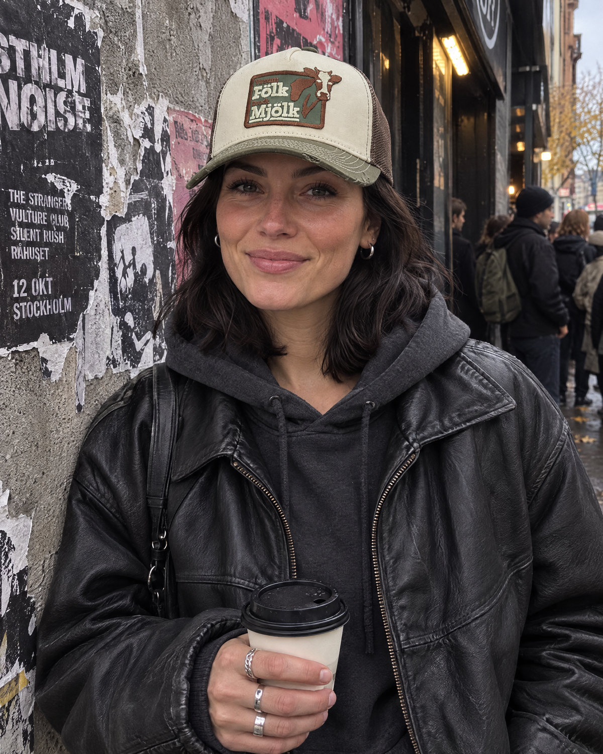 Woman wearing the Va som fölk dreck mjölk trucker cap on a city street.
