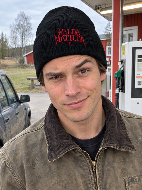 Milda Matilda på svart Hatitude Beanie, buren av en yngre vuxen.